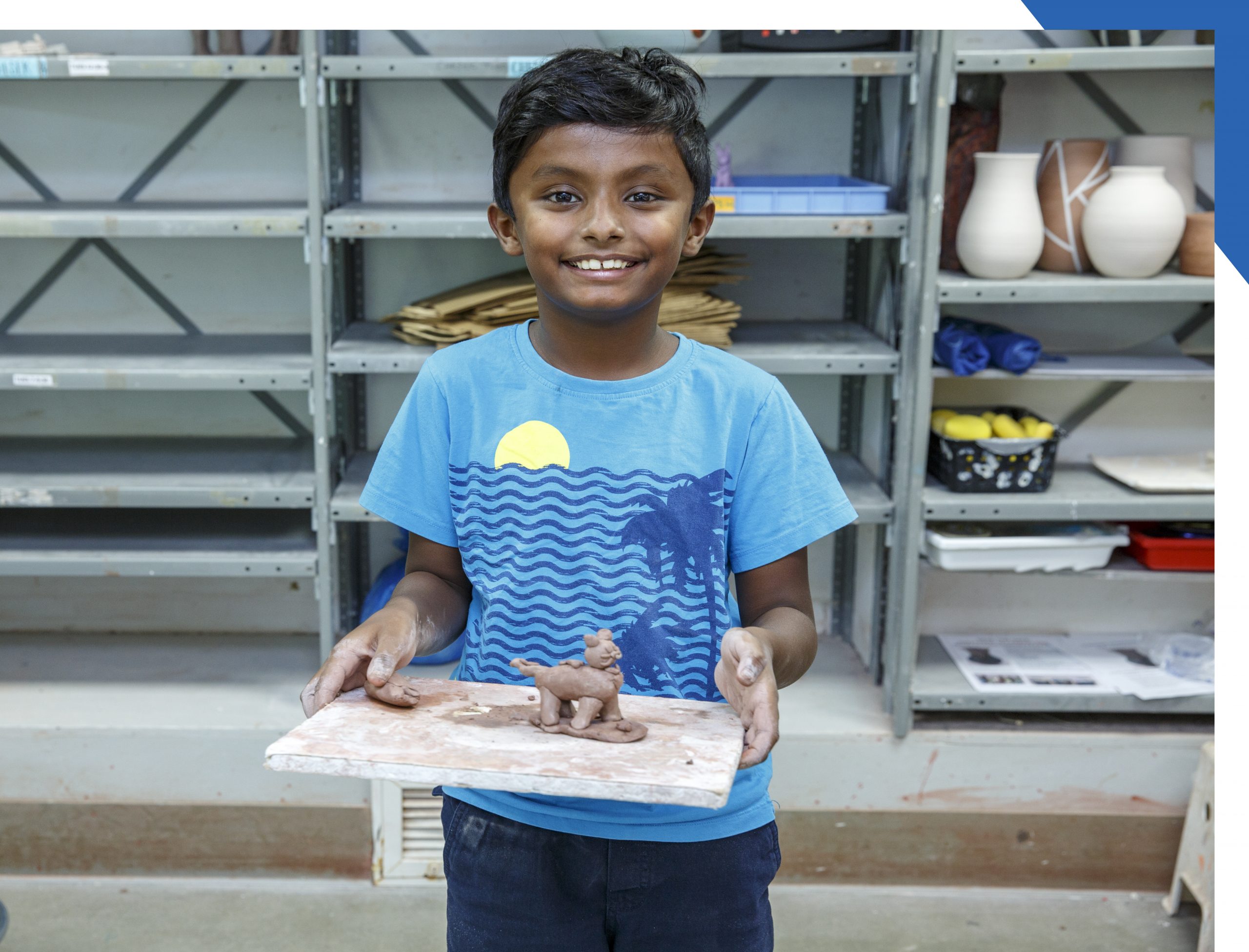 Smiling child showing his artwork