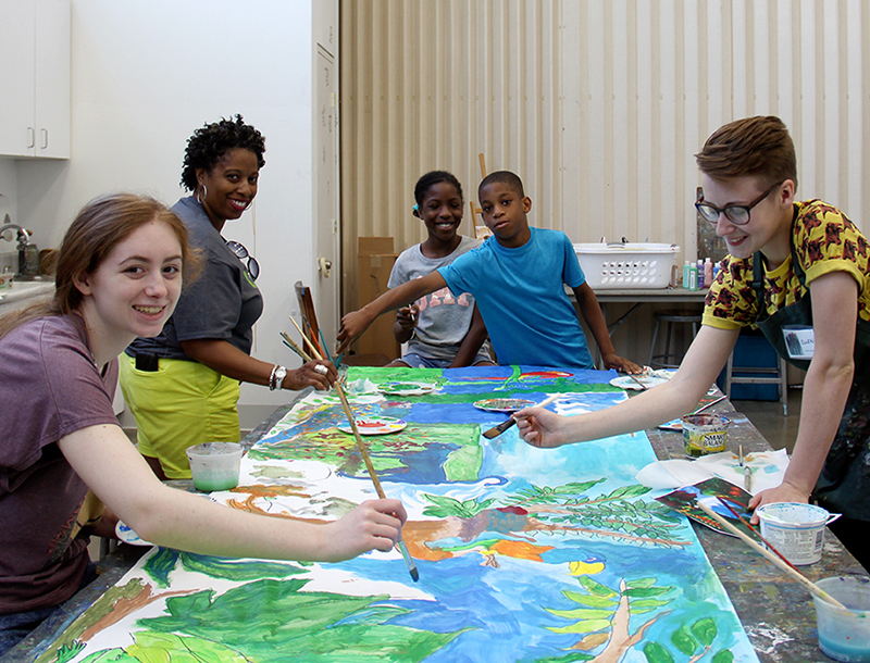 Young artists working on a painting.