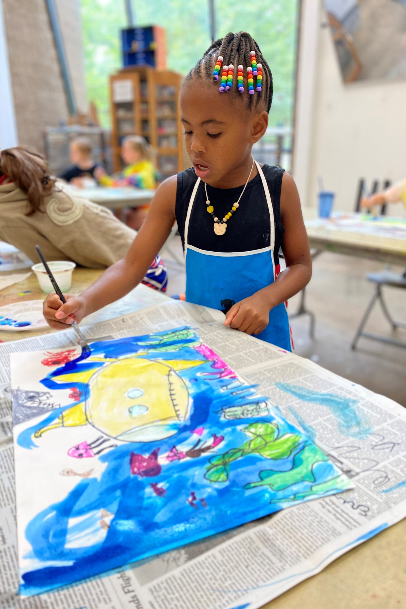 A child artist painting at the Art Center.