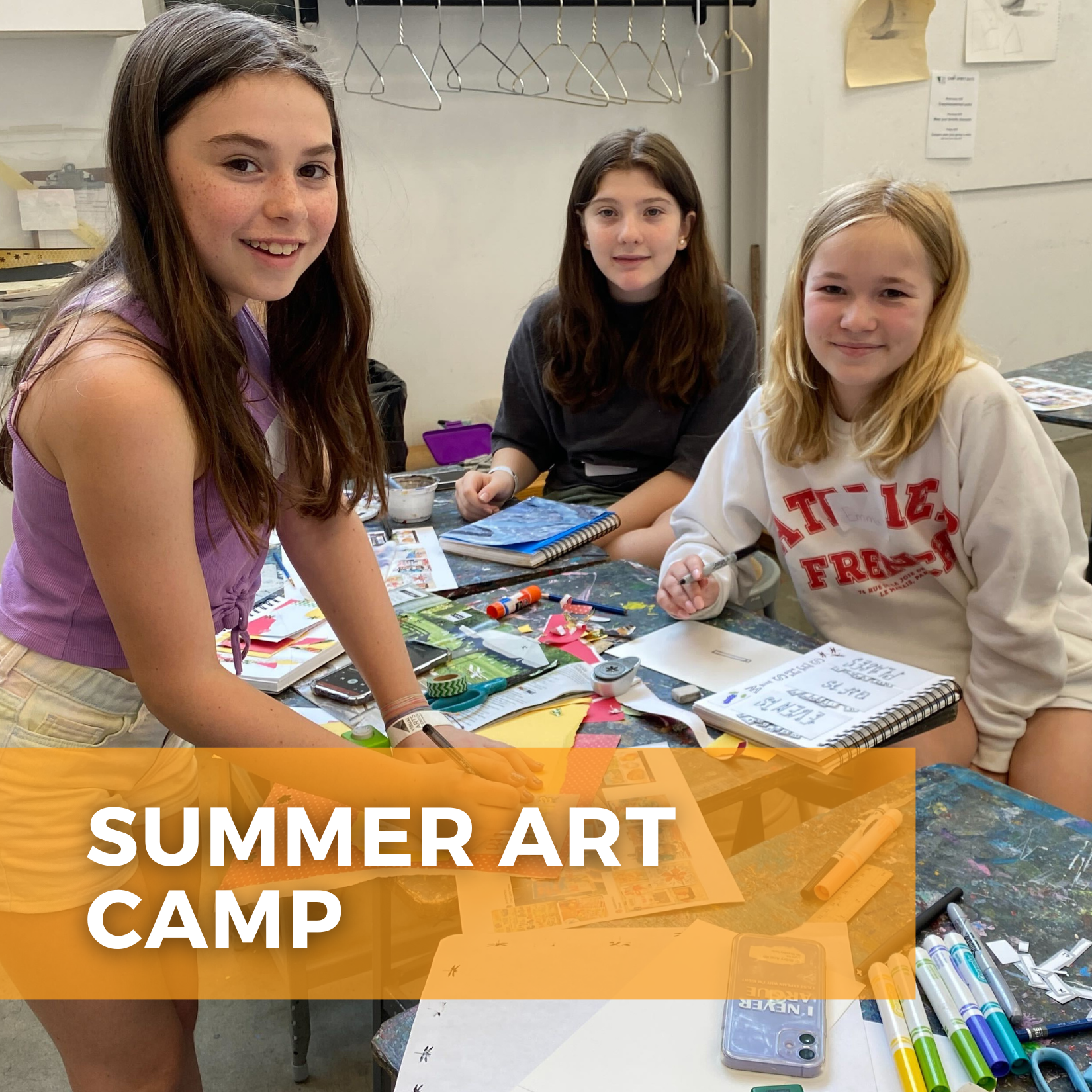 Three tween girls standing around a table creating artwork. It says "Summer Art Camp"